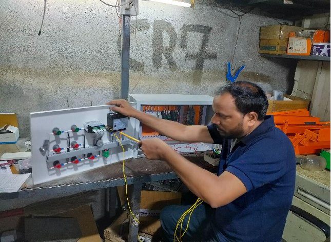 Engineer wiring the monitoring module to a chiller control panel