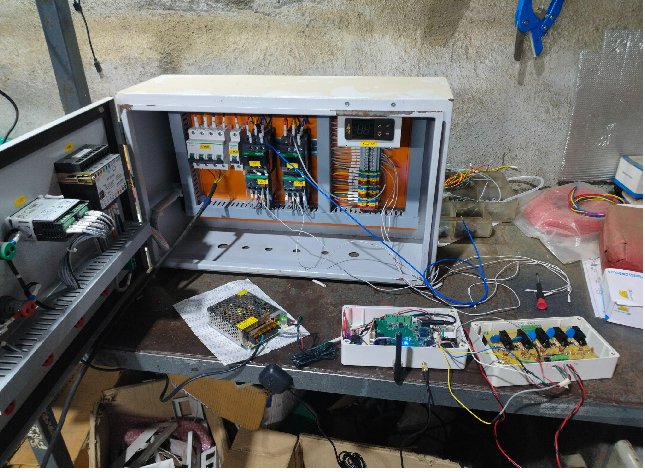Open chiller electrical panel with the digital input module and gateway on the bench